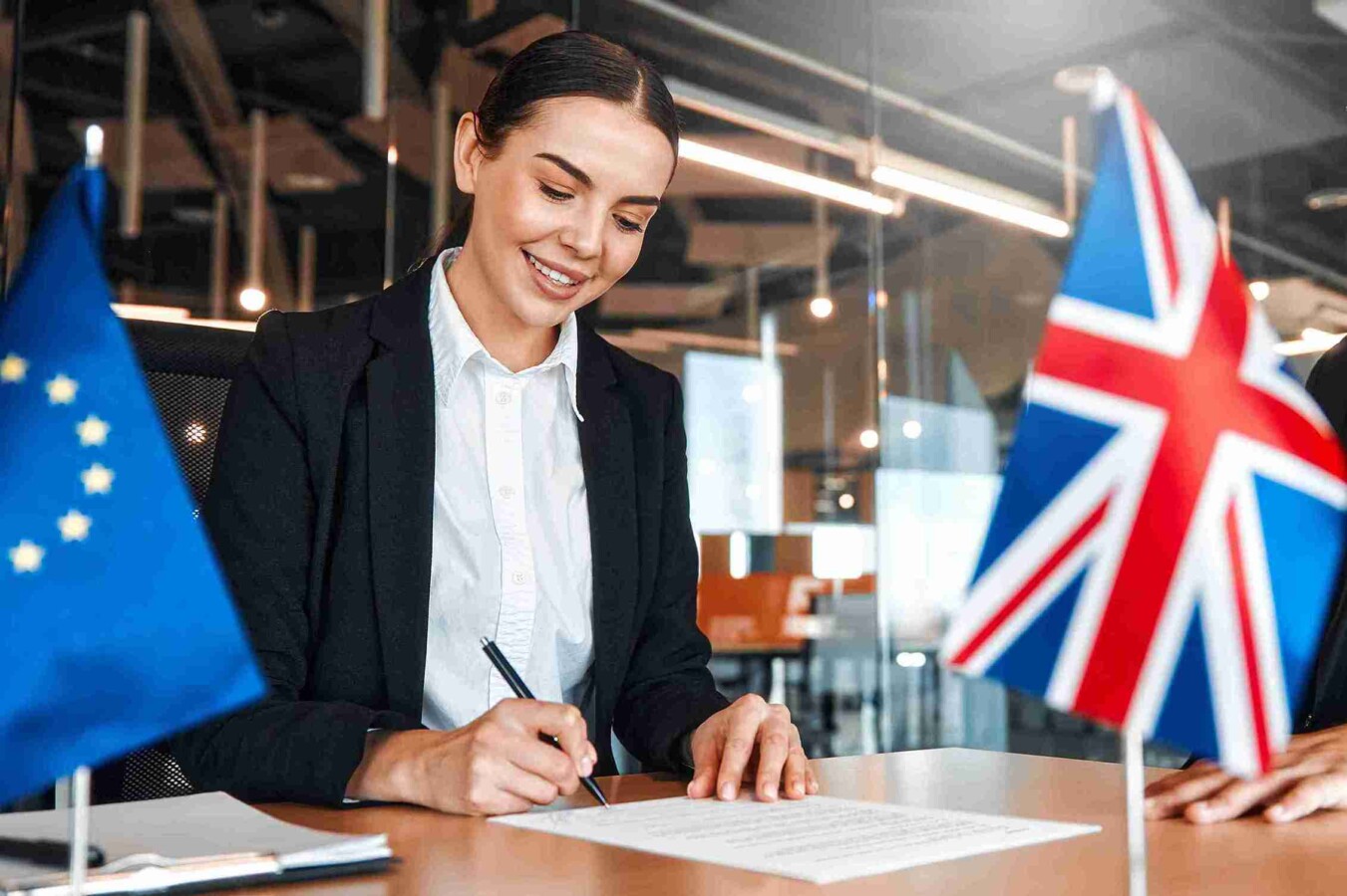 UK and EU leaders shake hands over a signed trade deal, symbolizing a new chapter post-Brexit.