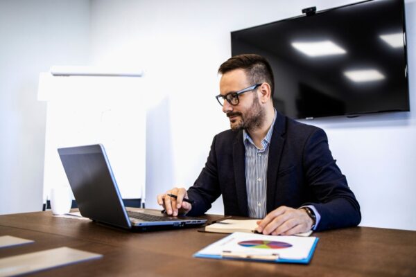 Guy check Tier 2 sponsor licence checklist in his laptop